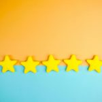 Bright yellow stars arranged on a vivid orange and blue background with copy space.