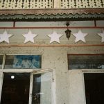 Low angle view of a vintage building facade featuring star decorations and intricate architectural details.